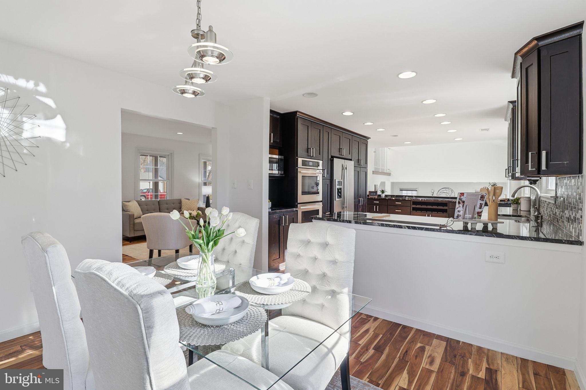 5207 Ruffner Woods Court Burke, VA 22015 - Photo 10 of 29 a view of a dining room with furniture a kitchen and chandelier