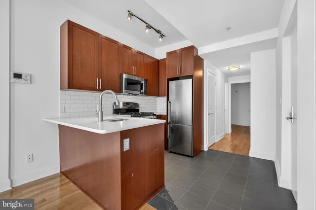 a kitchen with kitchen island a refrigerator and a sink