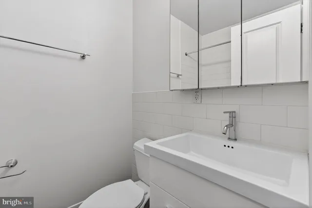 a white bath tub sitting next to a white toilet and vanity