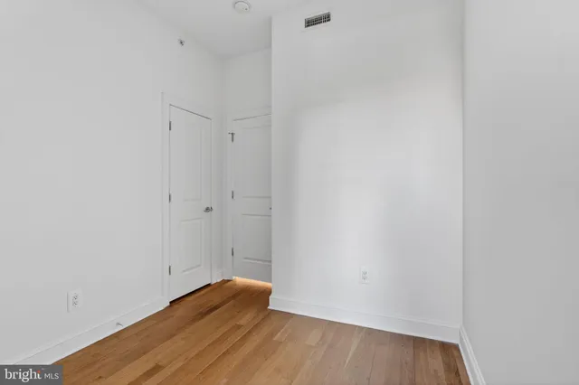 a view of an empty room with wooden floor