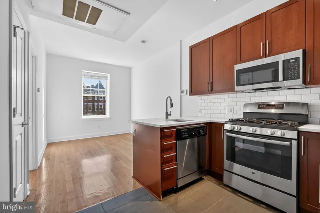 a kitchen with stainless steel appliances a stove microwave and sink