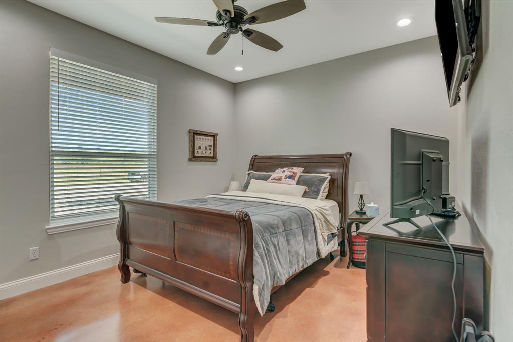 129 Whiskey Rnch Road Runaway Bay, TX 76426 - Photo 24 of 39 a bedroom with a bed and a chandelier