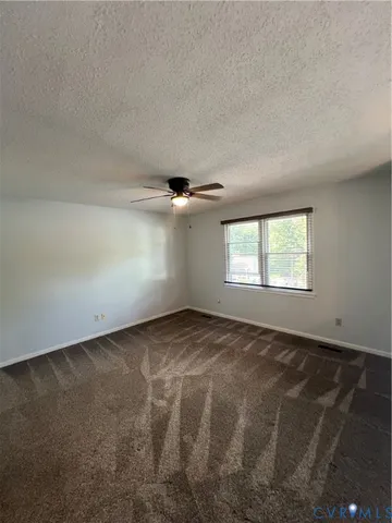 an empty room with windows and ceiling fan view