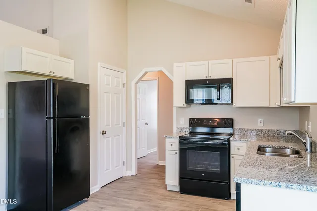 a kitchen with stainless steel appliances granite countertop a refrigerator stove and sink