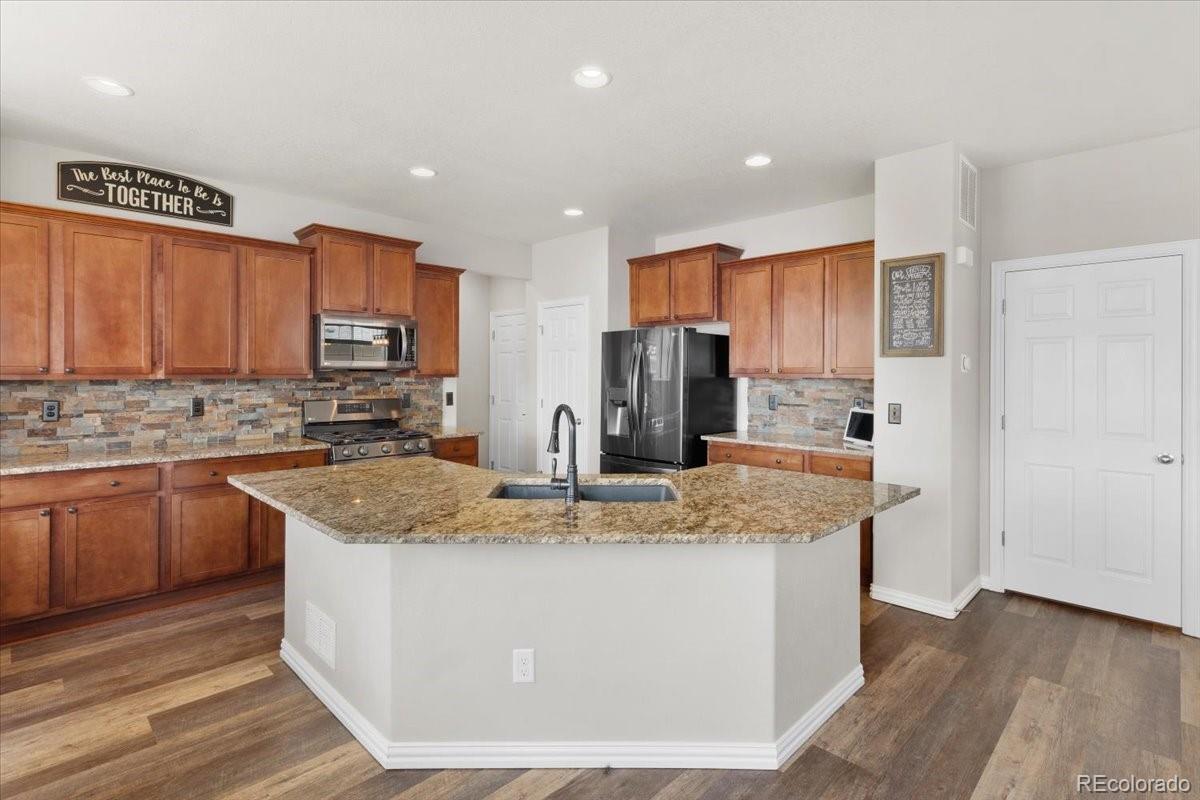 1906 Charbray Point Castle Rock, CO 80108 - Photo 12 of 44 a kitchen with stainless steel appliances granite countertop a stove a sink a refrigerator and a microwave