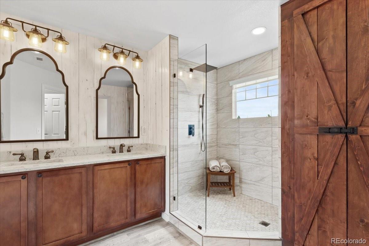 1906 Charbray Point Castle Rock, CO 80108 - Photo 21 of 44 a bathroom with a double vanity sink a mirror and a shower