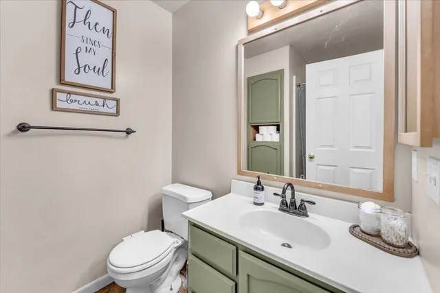 a bathroom with a toilet sink and mirror