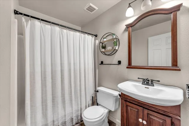 a bathroom with a sink vanity mirror and toilet