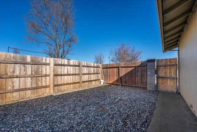 a view of backyard with wooden fence and large trees