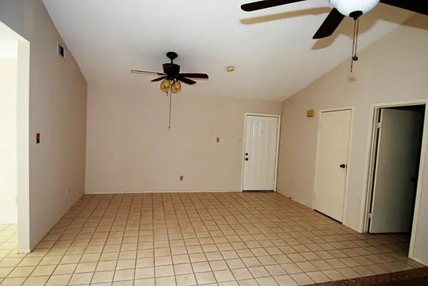 an empty room with a ceiling fan and a window