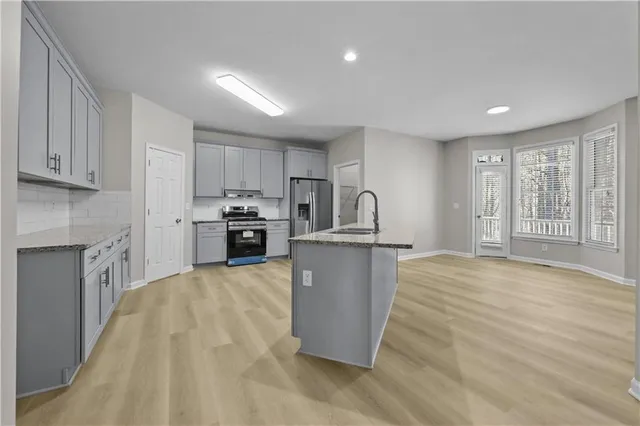 a kitchen with granite countertop a refrigerator and a sink