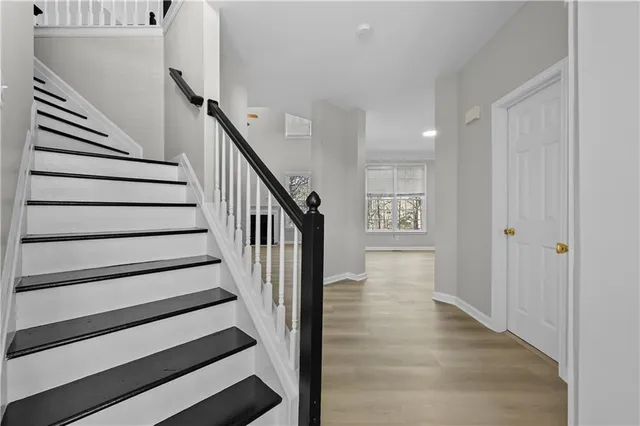 a view of entryway and hall with wooden floor