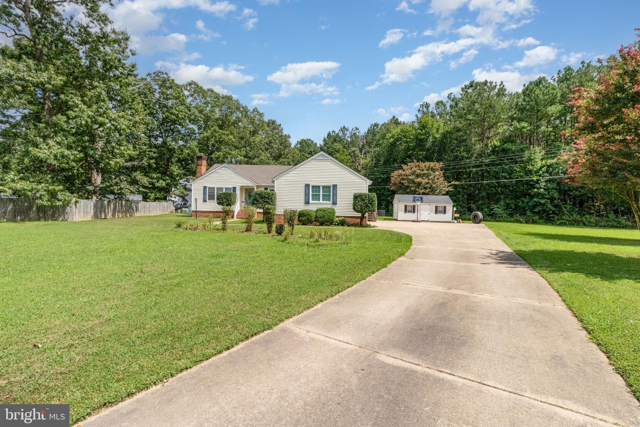 5212 Farmcrest Circle Prince George, VA 23875 - Photo 2 of 27 a front view of a house with a garden and trees