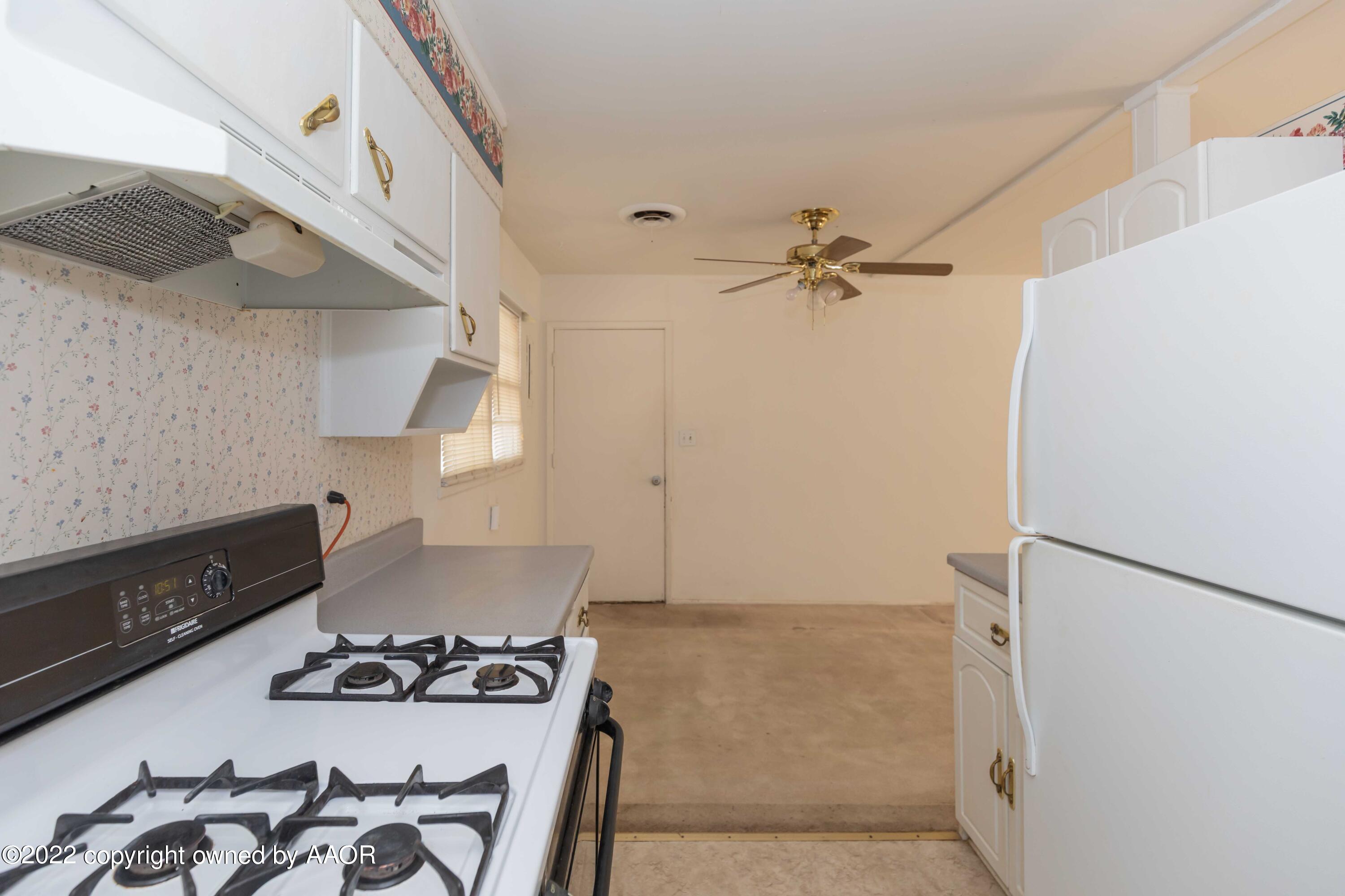 5138 Crockett Street Amarillo, TX 79110 - Photo 12 of 35 a kitchen with a stove and a refrigerator