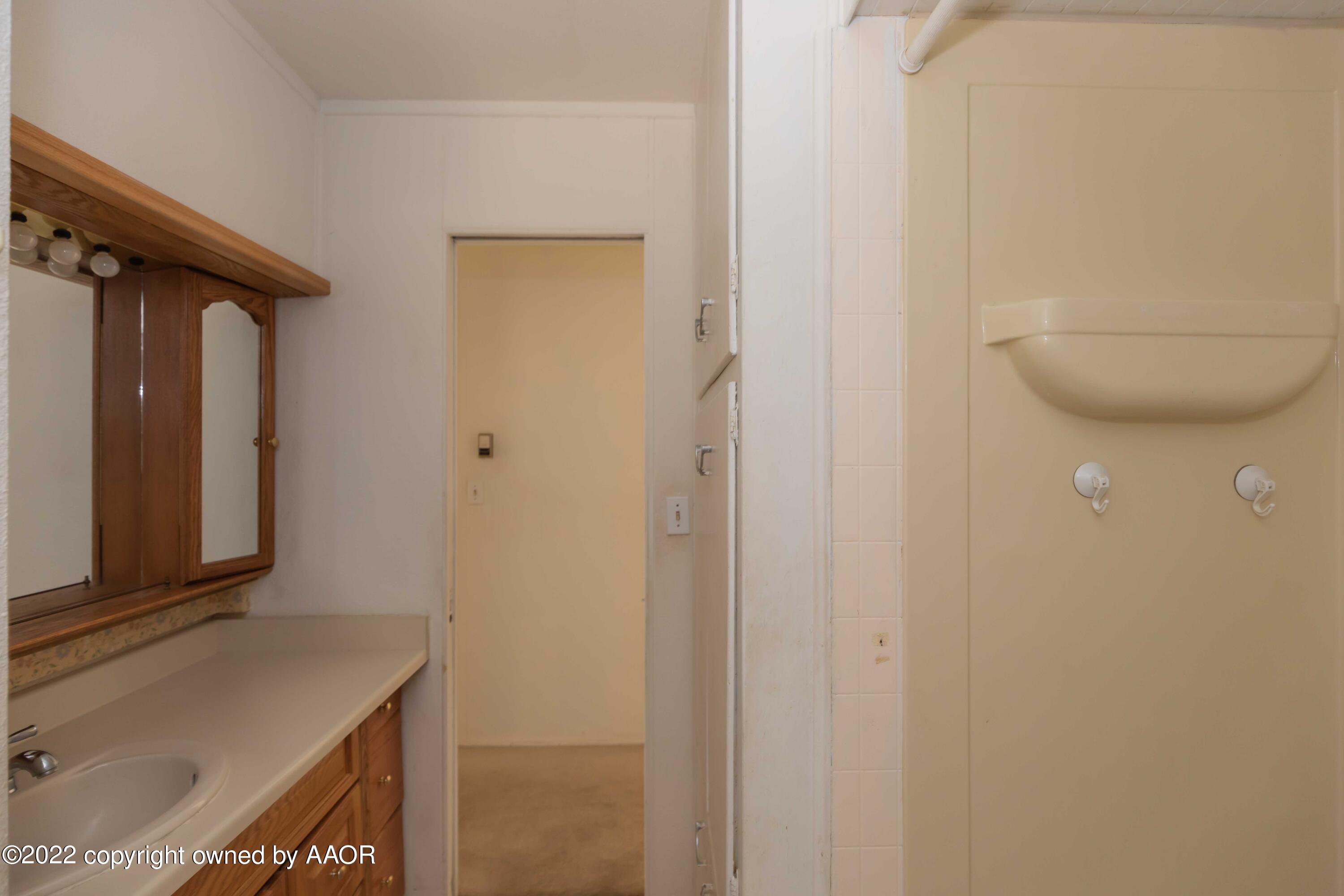 5138 Crockett Street Amarillo, TX 79110 - Photo 24 of 35 a bathroom with a sink a toilet and mirror