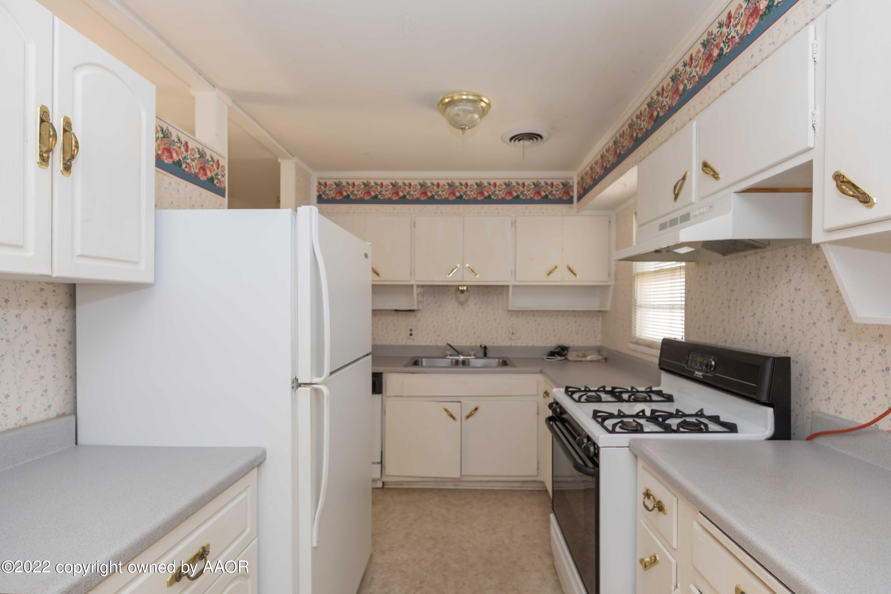 5138 Crockett Street Amarillo, TX 79110 - Photo 8 of 35 a kitchen with stainless steel appliances a stove a refrigerator and a sink