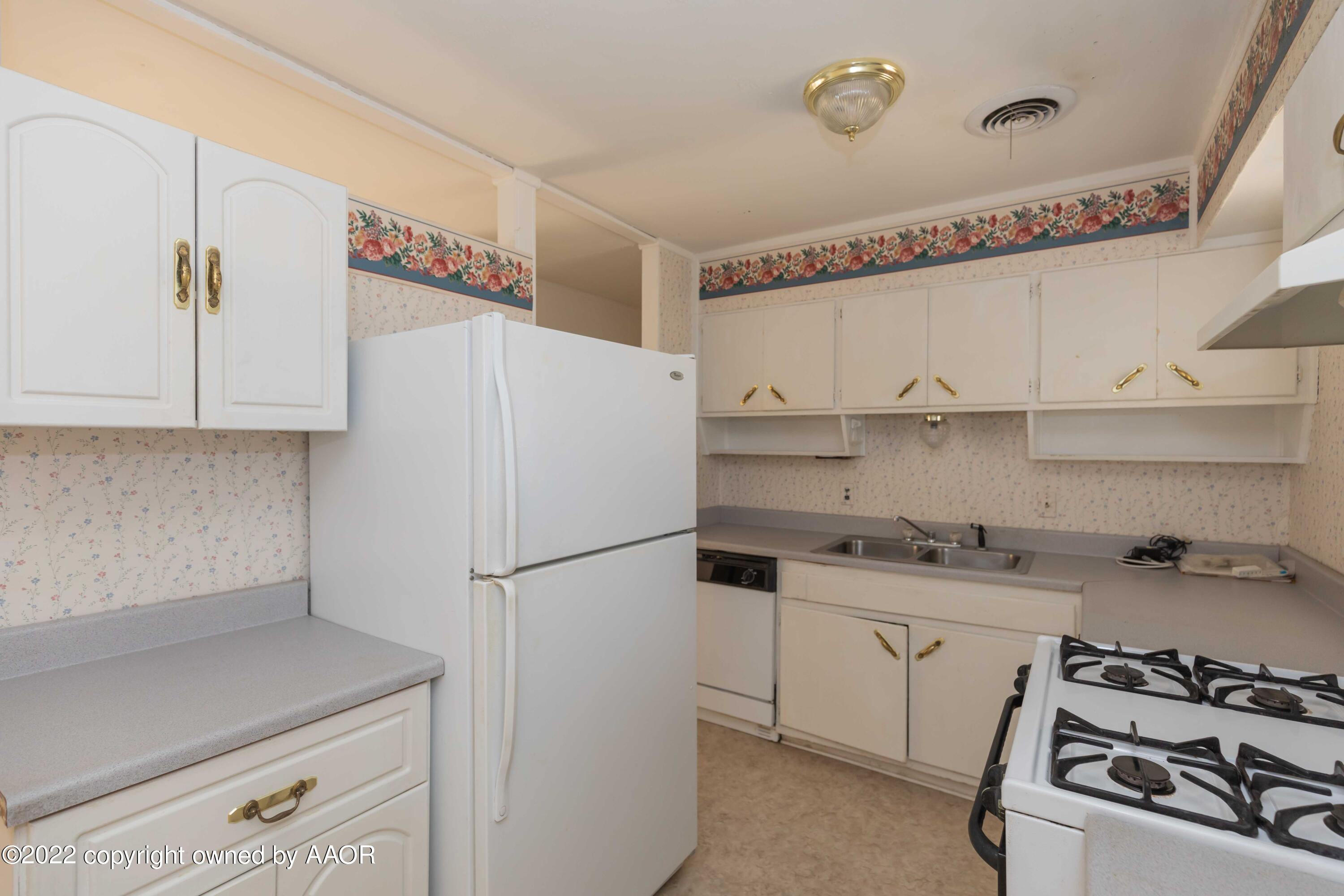 5138 Crockett Street Amarillo, TX 79110 - Photo 10 of 35 a kitchen with stainless steel appliances a sink and cabinets