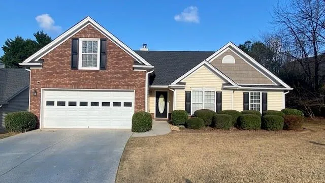 a front view of a house with yard and green space