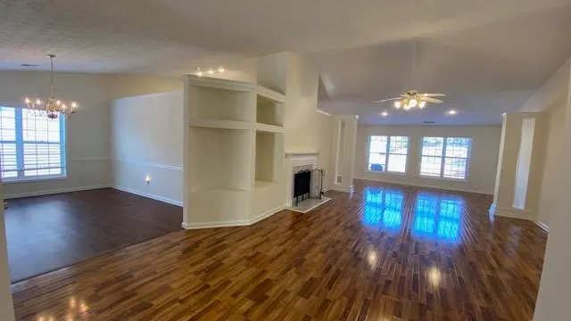 a view of an empty room with window and fireplace