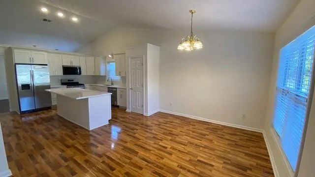 a kitchen with a sink and wooden floor