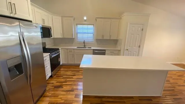 a kitchen with sink cabinets and wooden floor
