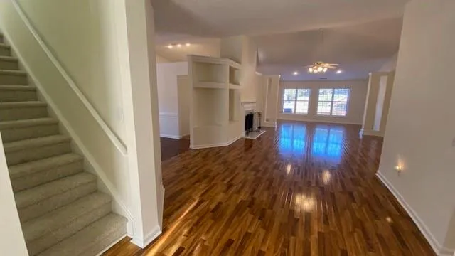 a view of a hallway with wooden floor and entryway