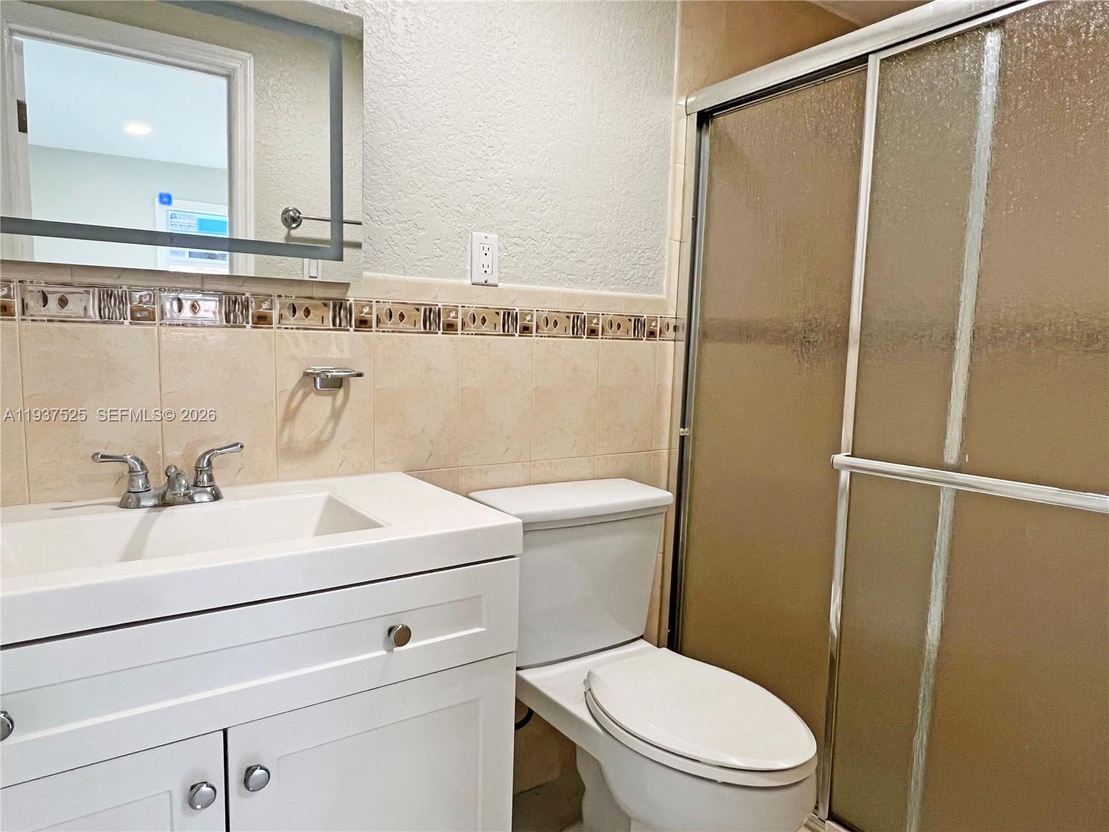 11962 Southwest 37th Terrace Miami, FL 33175 - Photo 21 of 24 a bathroom with a sink a toilet and a mirror