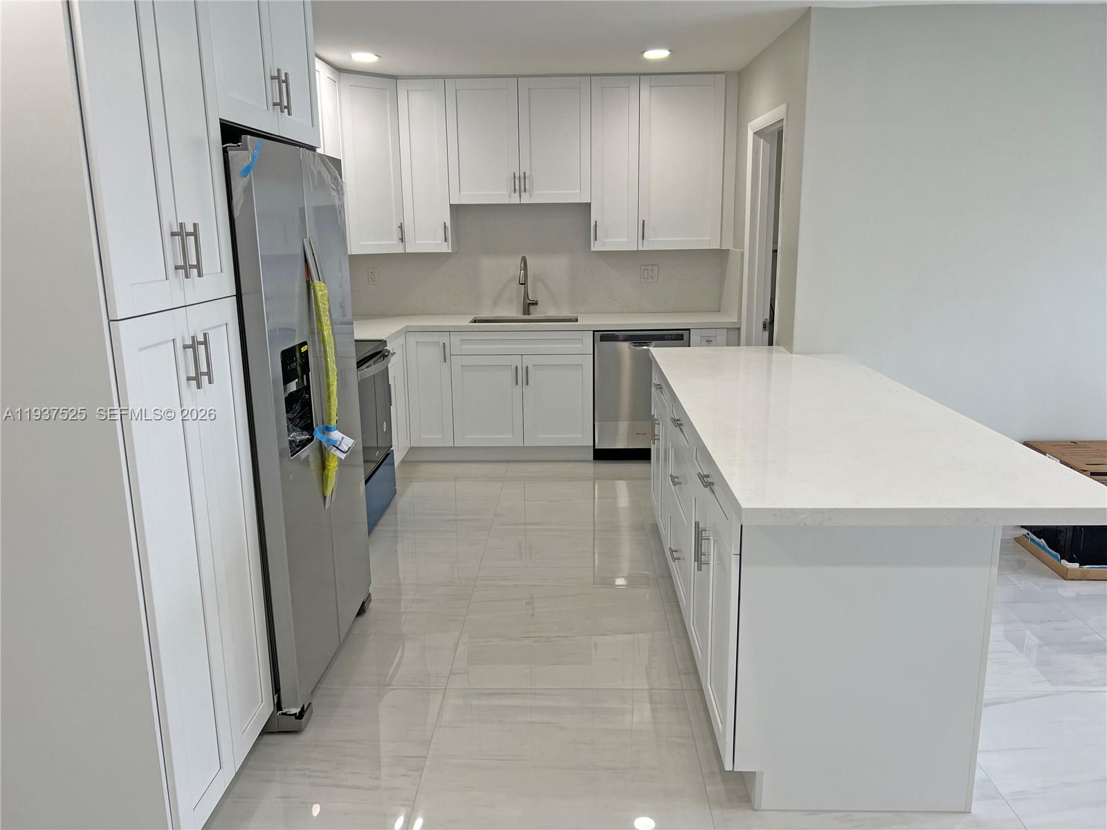 11962 Southwest 37th Terrace Miami, FL 33175 - Photo 7 of 24 a kitchen with refrigerator a sink and cabinets