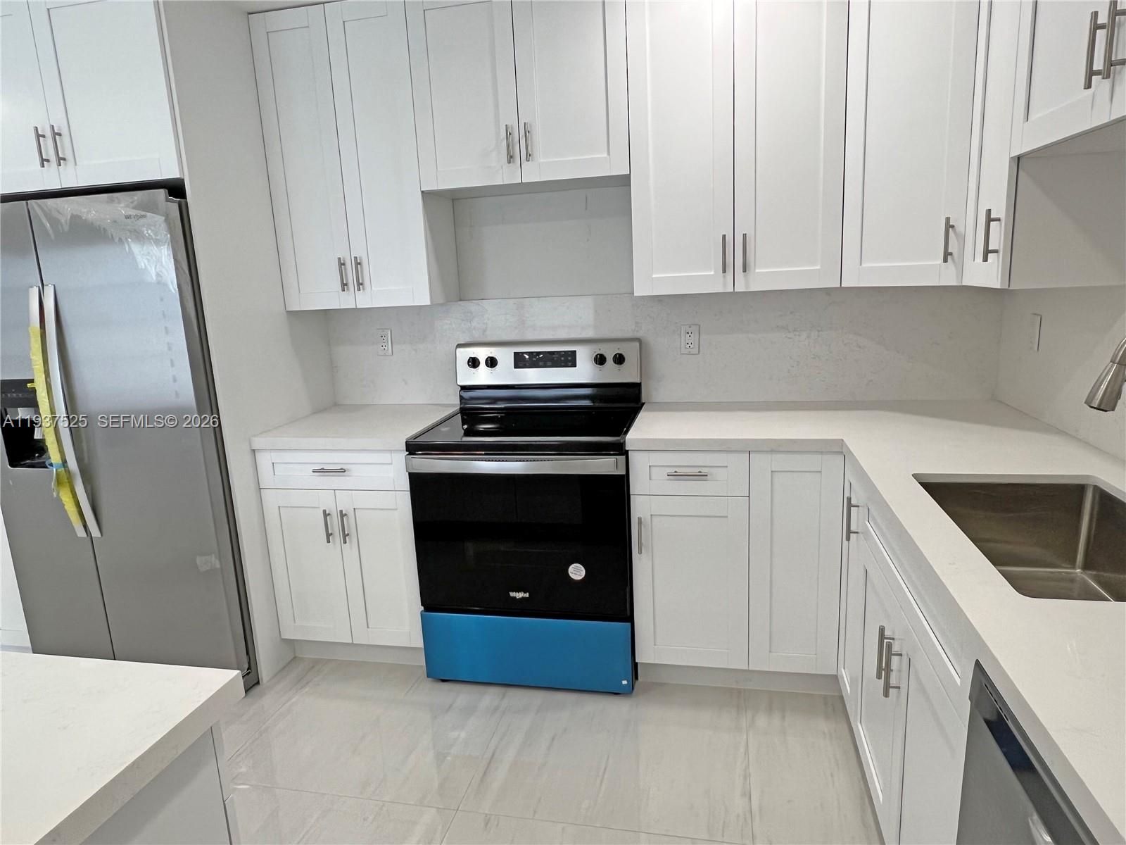 11962 Southwest 37th Terrace Miami, FL 33175 - Photo 8 of 24 a kitchen with white cabinets and white appliances