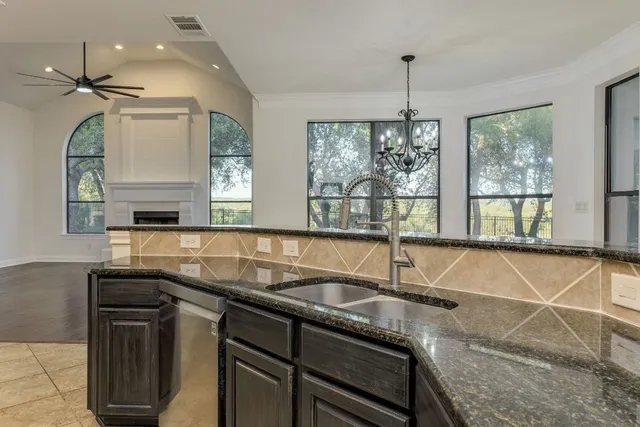 a kitchen with granite countertop a sink and a stove
