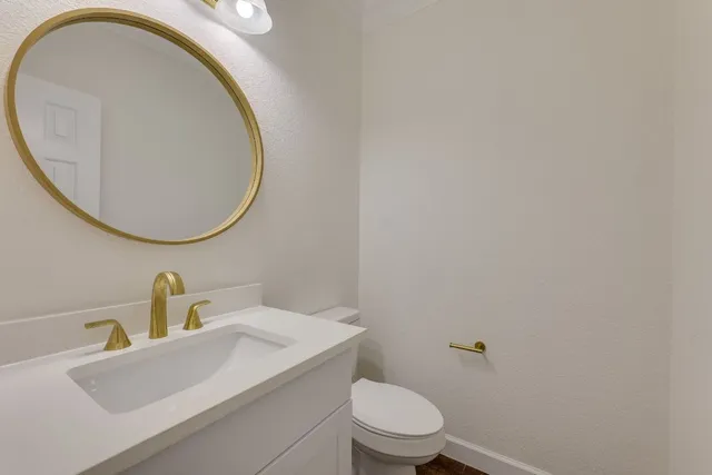 a bathroom with a sink a toilet and a mirror