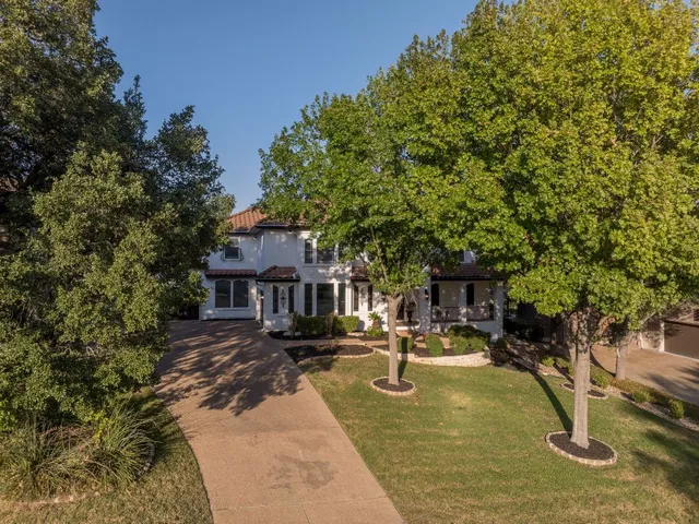 an aerial view of a house with garden space and trees all around