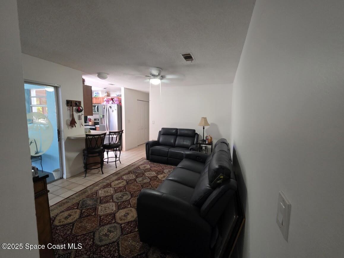 250 Perth Avenue Merritt Island, FL 32953 - Photo 11 of 48 a living room with furniture and a flat screen tv