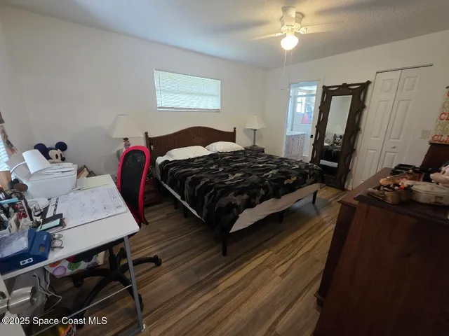 a bedroom with a bed wooden floor and dresser