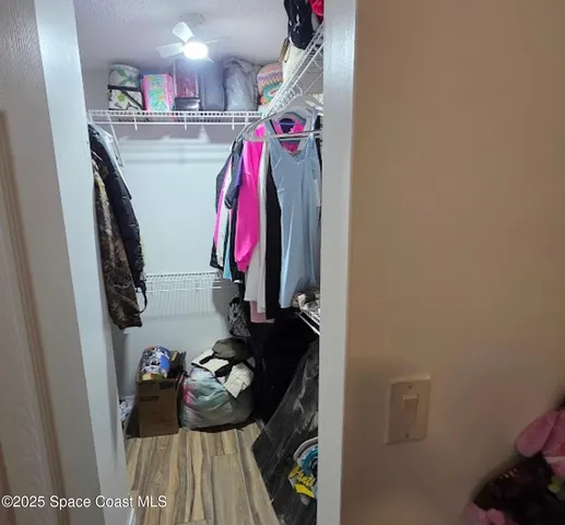 a view of walk in closet with clothes and shoes