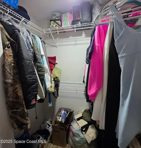 a view of walk in closet with clothes and shoes