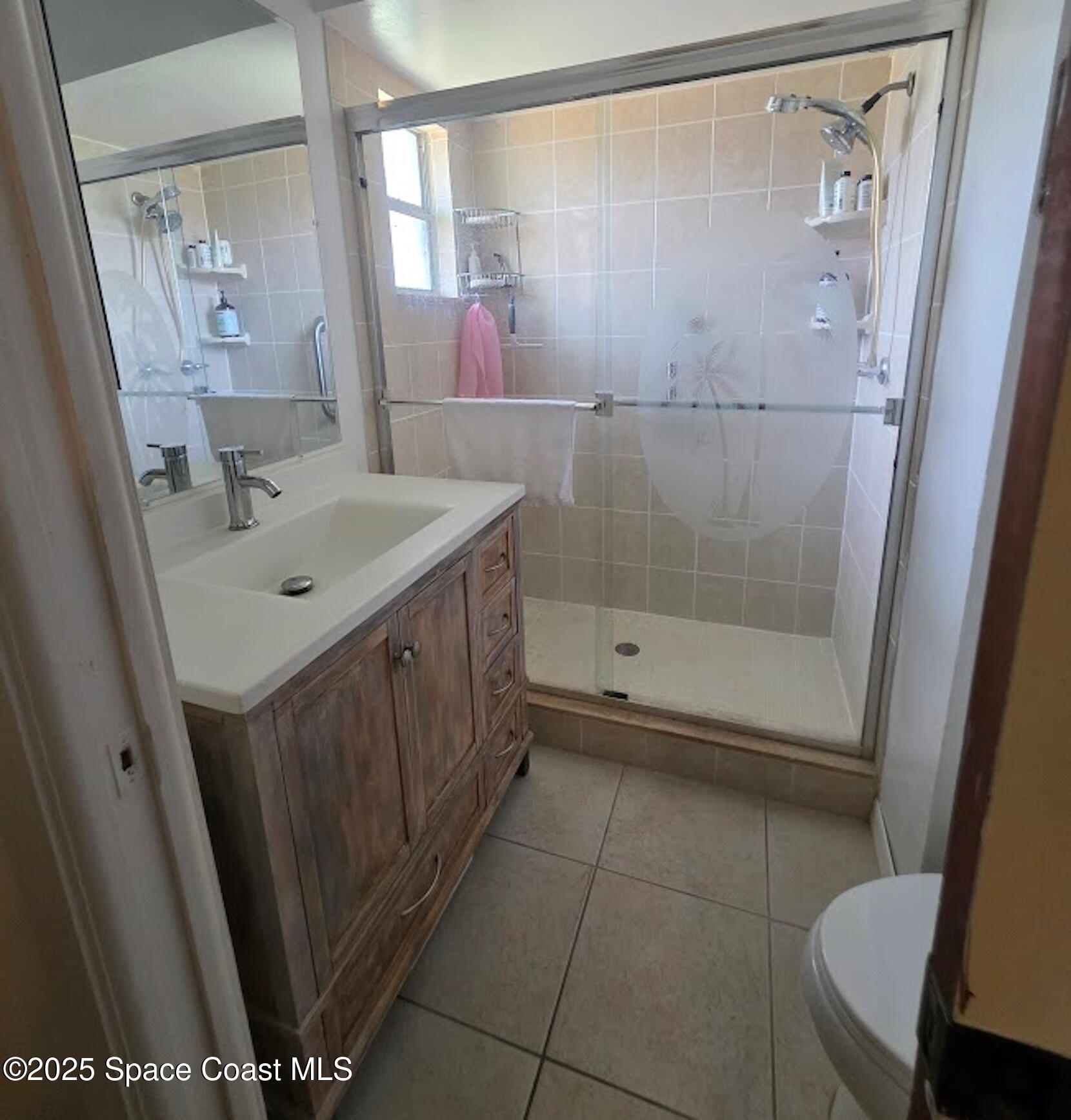 250 Perth Avenue Merritt Island, FL 32953 - Photo 30 of 48 a bathroom with a sink a toilet a mirror and shower