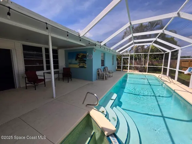 a view of a backyard with a small deck and a garden