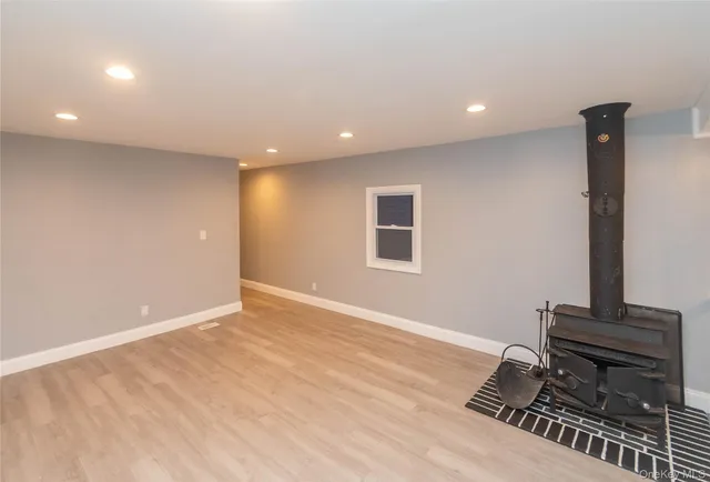 a view of room with a piano and wooden floor