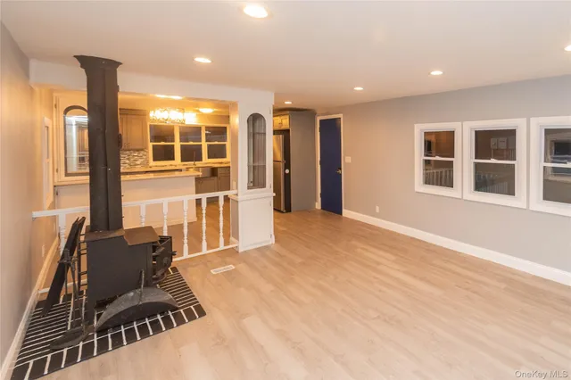 a living room with furniture stove and large window