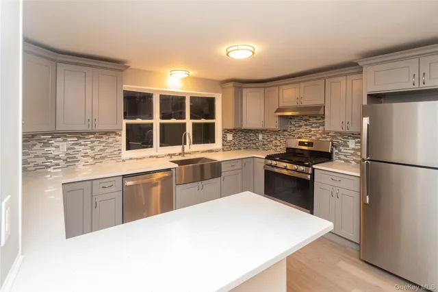 a kitchen with a refrigerator stove top oven and sink