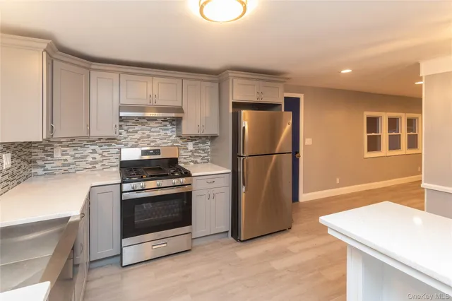 a kitchen with a refrigerator sink stove and cabinets