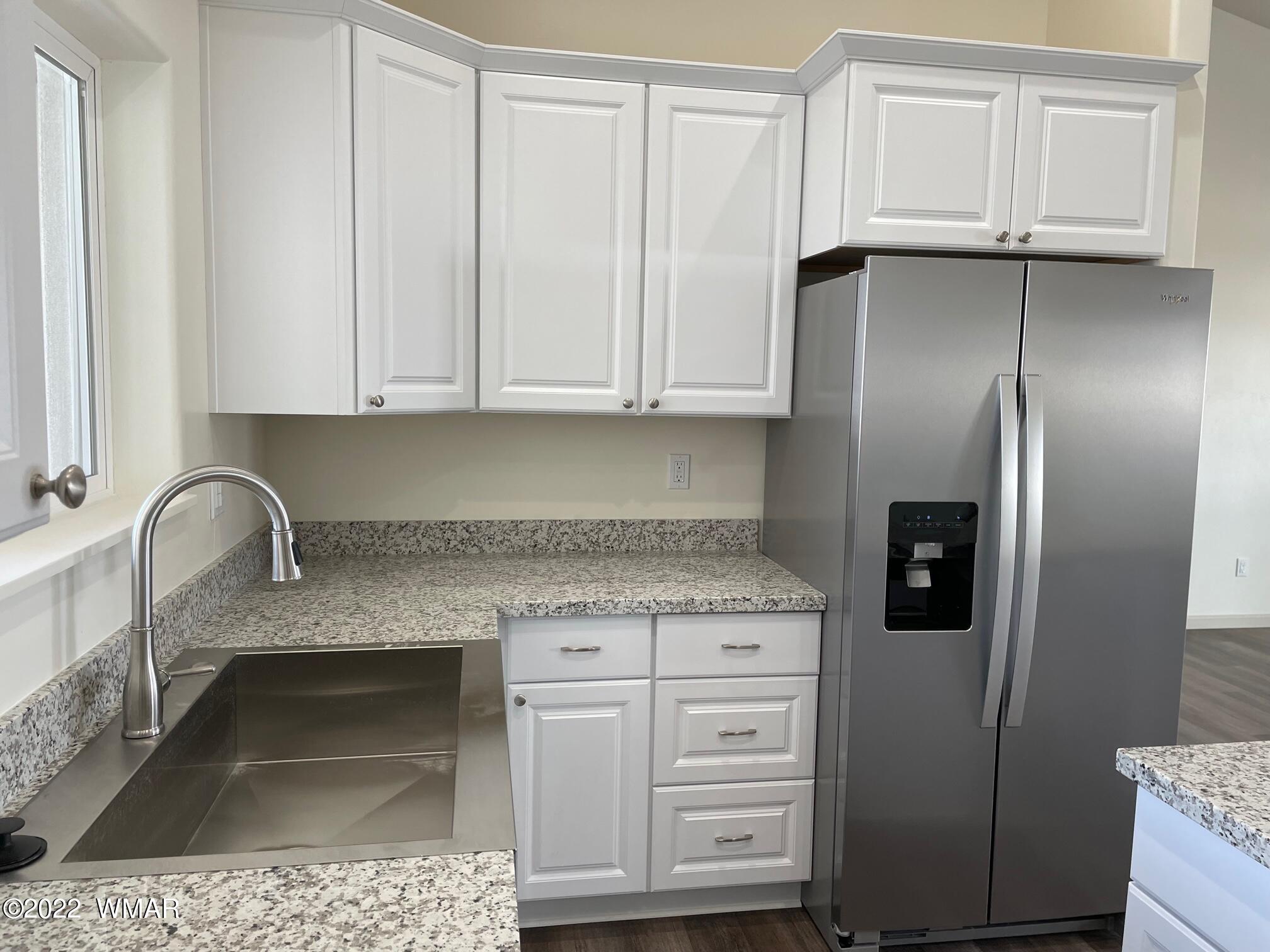 442 Susie Lane Springerville, AZ 85938 - Photo 12 of 46 a kitchen with granite countertop a refrigerator sink and cabinets