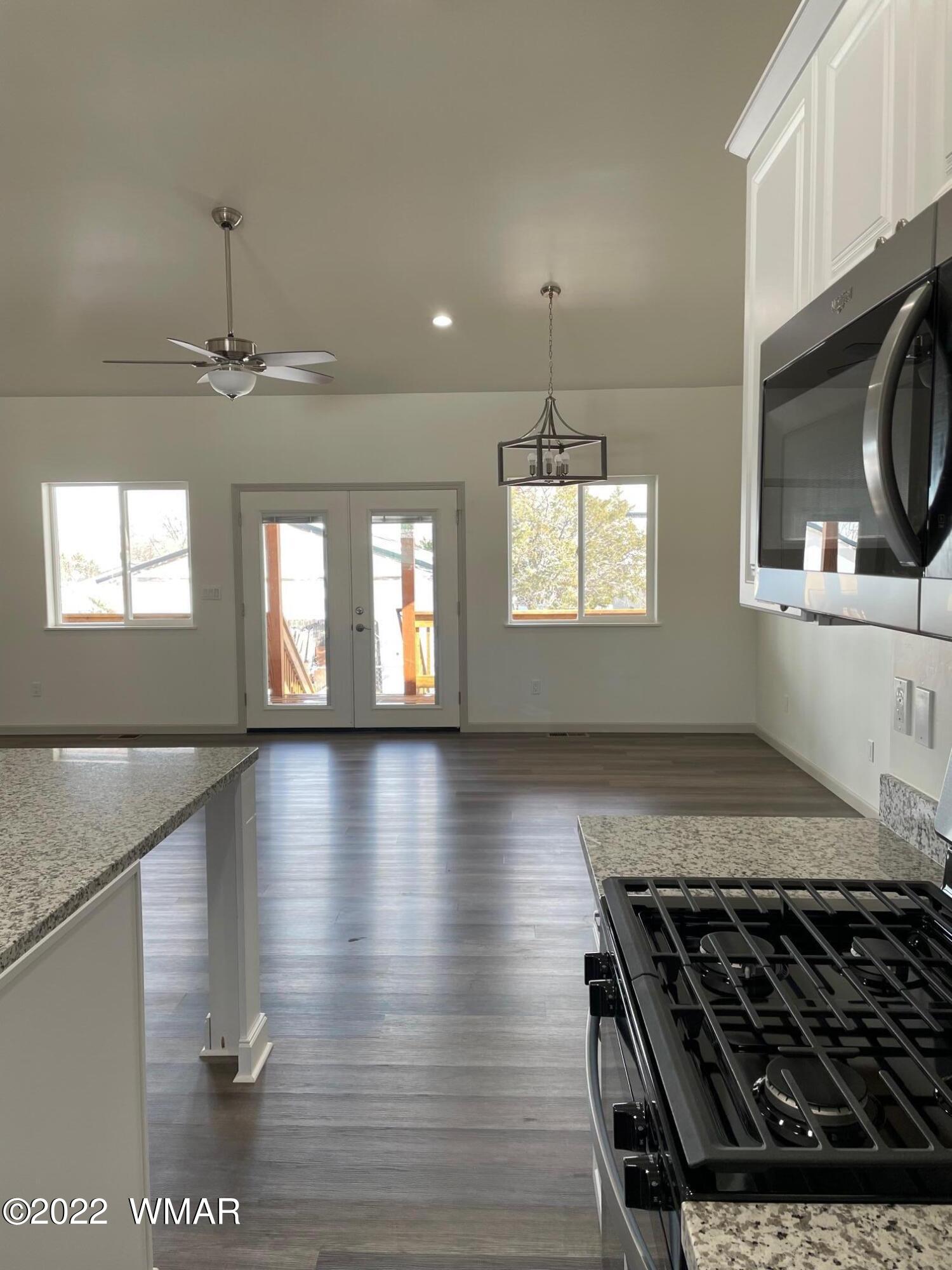 442 Susie Lane Springerville, AZ 85938 - Photo 14 of 46 a kitchen with granite countertop a stove and a wooden floor