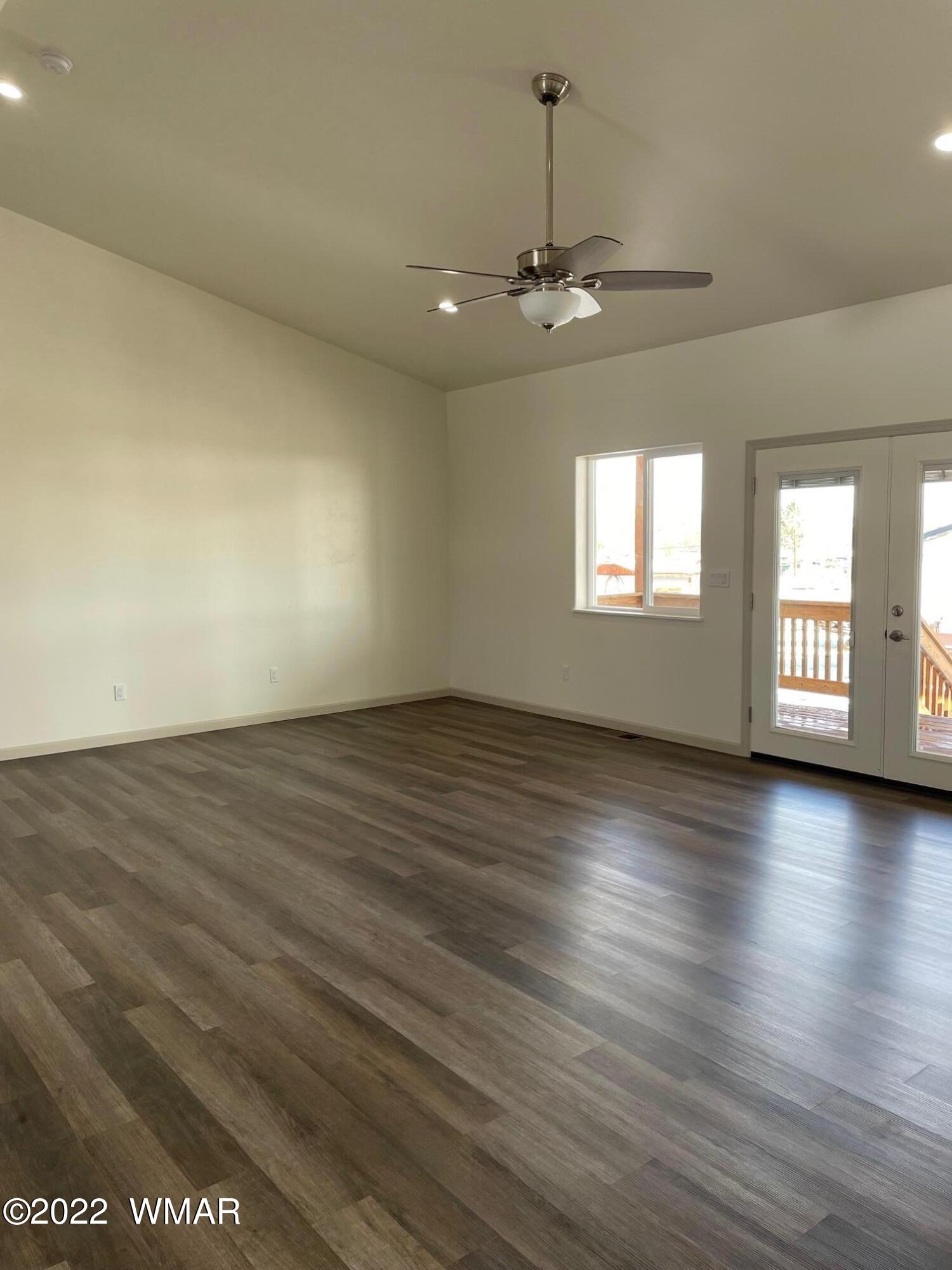 442 Susie Lane Springerville, AZ 85938 - Photo 18 of 46 an empty room with wooden floor chandelier and windows