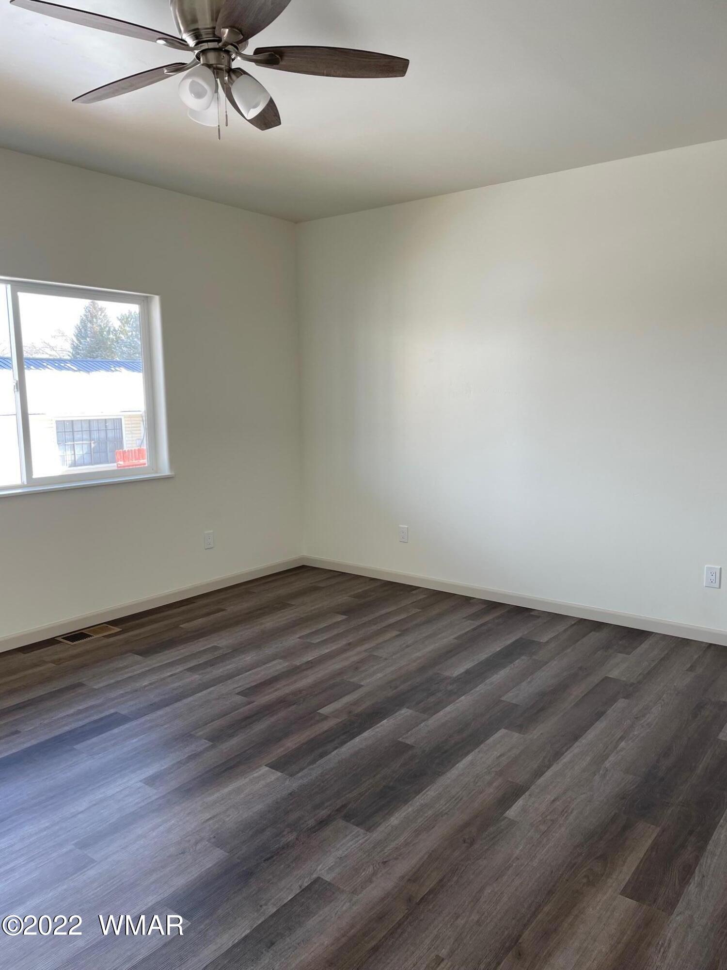 442 Susie Lane Springerville, AZ 85938 - Photo 19 of 46 an empty room with wooden floor fan and windows