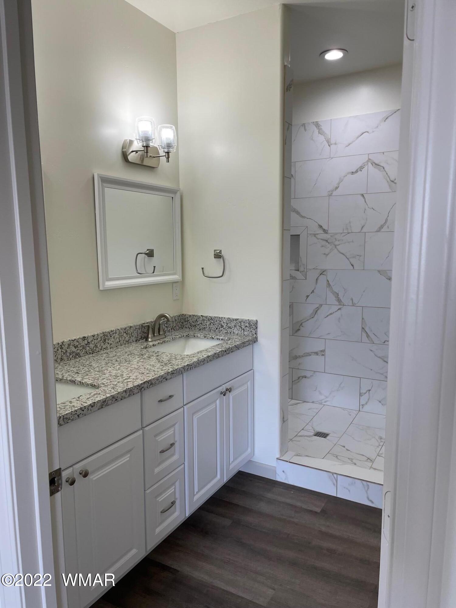 442 Susie Lane Springerville, AZ 85938 - Photo 26 of 46 a bathroom with a granite countertop sink a mirror and a shower