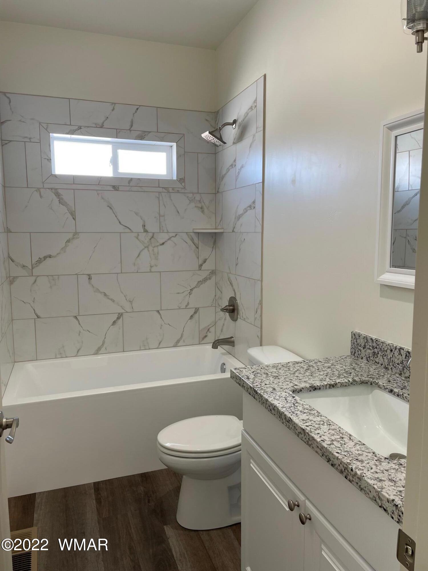 442 Susie Lane Springerville, AZ 85938 - Photo 37 of 46 a bathroom with a granite countertop sink a toilet and bathtub