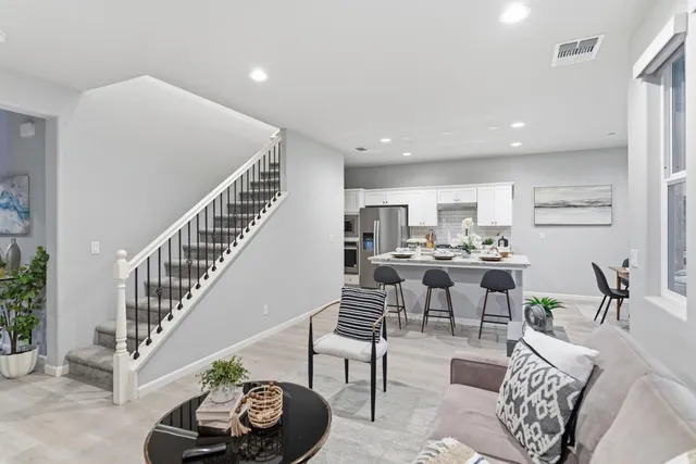 a living room with furniture and a dining table with kitchen view