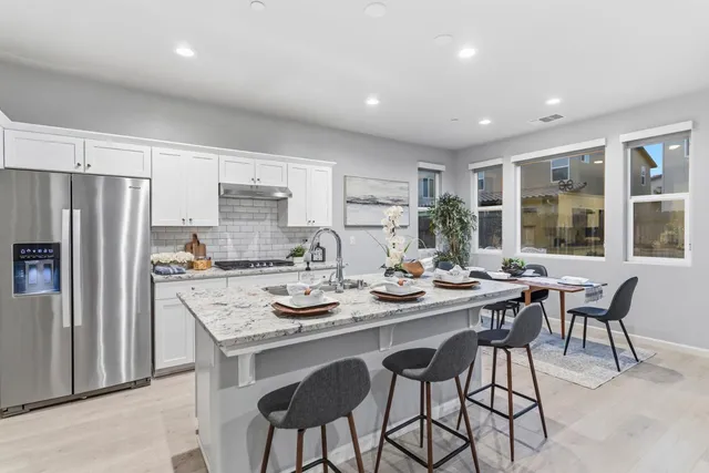 a kitchen with a table chairs refrigerator and cabinets